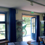 Het museumcafé met de dubbele deuren geopend naar het terras.